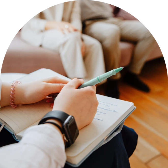 Hands writing notes in book
