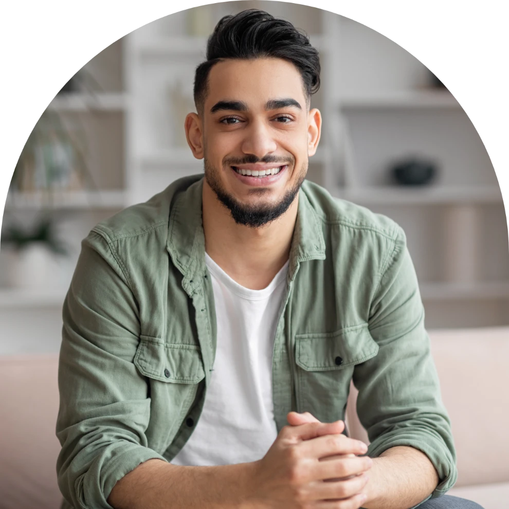Man in white tee and green long sleeve shirt sitting on chair
