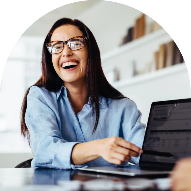 Smiling woman pointing to laptop