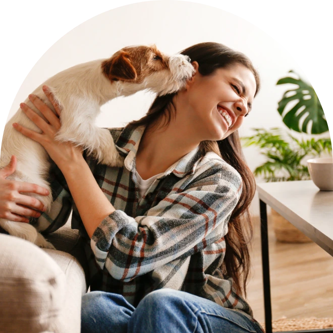 Woman sitting with dog licking her face